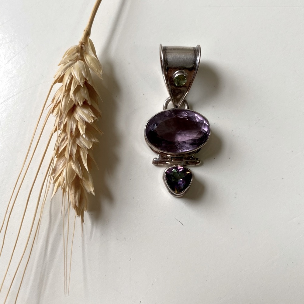 Purple gemstone in silver setting pendant